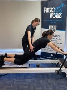 Client performing a controlled reformer Pilates leg press movement