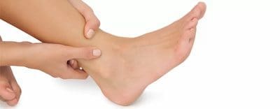foot-and-ankle-pain Person holding their foot and ankle gently to provide support and comfort.