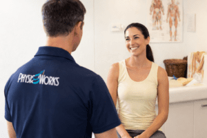 Physiotherapist providing muscle treatment during consultation for acute muscle injury