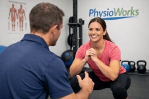 Closed kinetic chain exercises with physiotherapist guiding squat technique