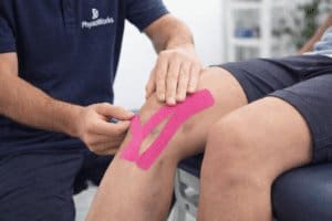 Kinesiology tape applied to a knee to help manage swelling and bruising