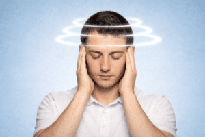 TMJ dizziness symptoms shown by male holding temples during jaw-related vertigo