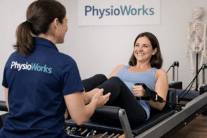 Reformer Pilates Sandgate physio guiding client on reformer