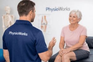 Physiotherapist assessing knee arthritis and discussing treatment options with patient
