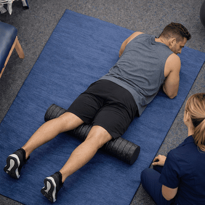 muscle-recovery-foam-roller-quadriceps-physiotherapy Muscle recovery quadriceps foam rolling exercise during physiotherapy-guided recovery session after training
