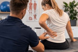 physiotherapist assessing lower back pain during musculoskeletal pain consultation