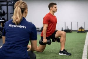 Pre-Season Conditioning physiotherapist supervising athlete during dumbbell lunge strength training