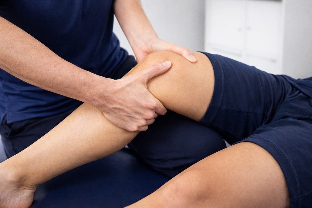 ACL Lachman test knee assessment by physiotherapist stabilising femur and tibia movement