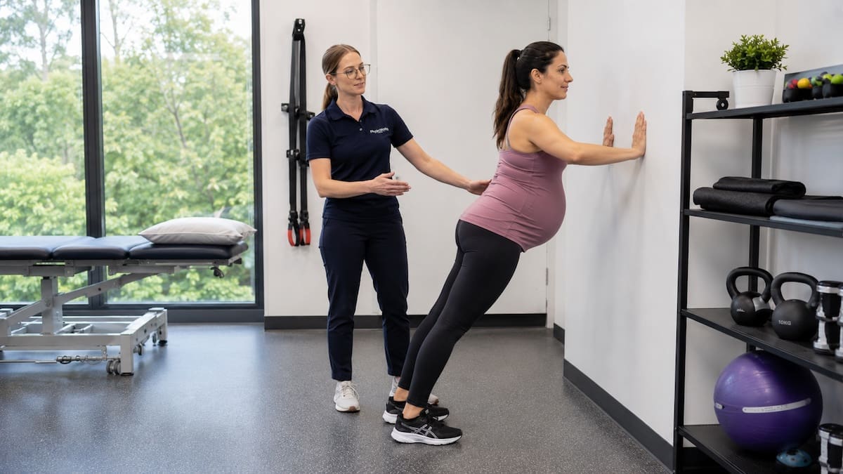 Safe pregnancy exercises with physiotherapist coaching wall push-up