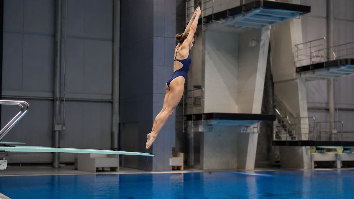 Springboard and Platform Diving Injuries Competitive diver performing a controlled springboard take-off above an indoor diving pool
